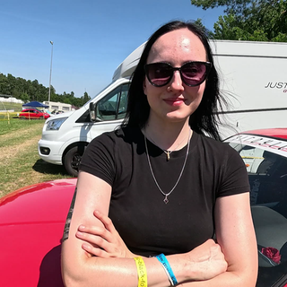 Megan steht lässig vor ihrem 5er BMW