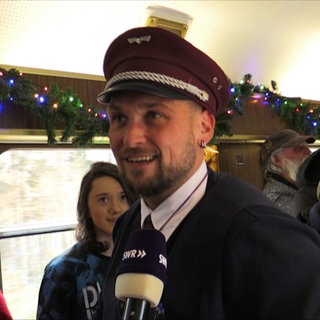 Besucher bestellen sich Punsch im Stuttgarter Weihnachtszug