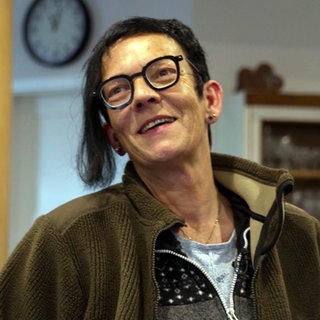 Claudia Walz trägt eine schwarze Brille, kurze Haare mit einer langen Strähne und Ohrringe.