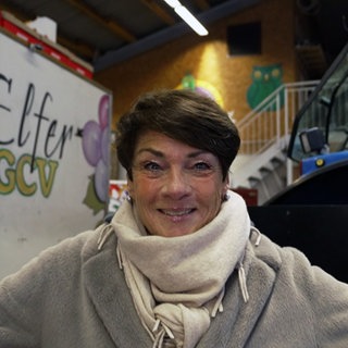 Sonja Faber-Schrecklein steht vor einem Fastnachtswagen in Gundelsheim