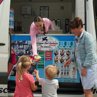 Frau verkauft Speiseeis aus Eismobil