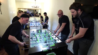 Timo Zipper spielt mit drei Personen Tischkicker.