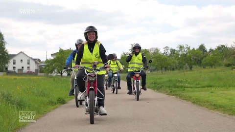 Mehrere Mofabegeisterte während einer gemeinsamen Mofa-Tour