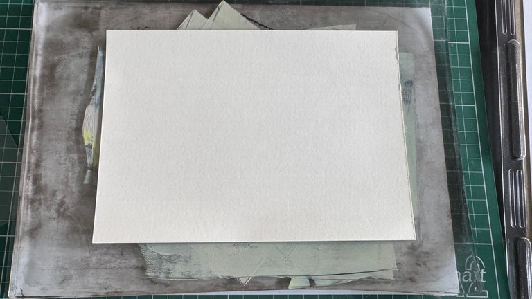 Eine letzte Farbschicht wird aufgetragen und direkt danach das Druckpapier auf die Platte gelegt. 