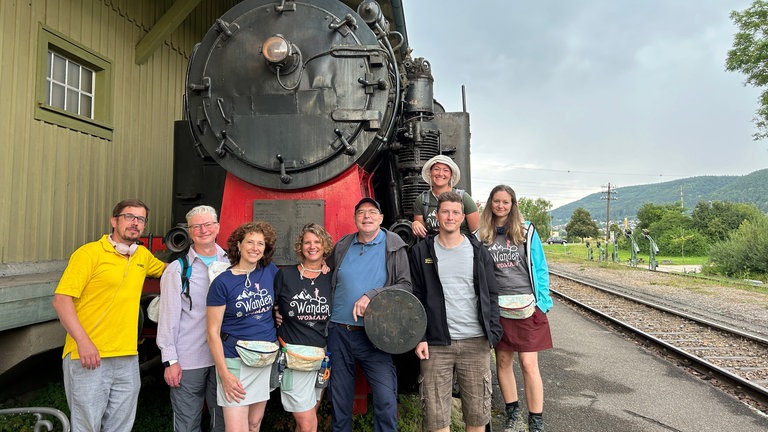 Der Perfekte Tag mit der Sauschwänzlebahn: von links nach rechts - SWR1 Moderator Ingo Lege mit Toby, Judith, Gewinnerin Daniela Nonnenmacher, Udo, Joël, Jenny und Sina, vor der großen Dampflok der Sauschwänzlebahn. 