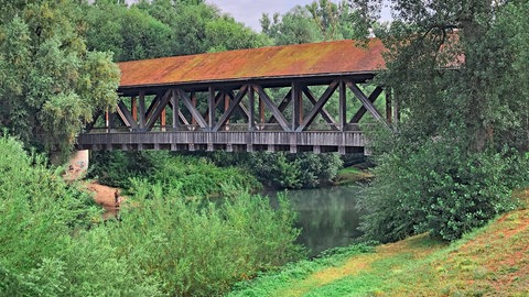 Eine Holzbrücke führt über den Kraichbach. Der Radweg führt überwiegend bergab. Deshalb ist der Kraichradweg ein sehr guter Tipp für einen Ausflug mit der ganzen Familie.