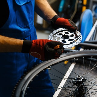 Mann schraubt an Fahrrad