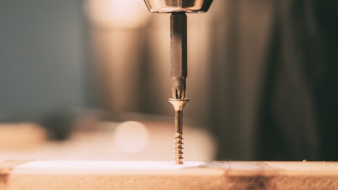 Vorbohren eines Holzstücks mit Akkubohrer
