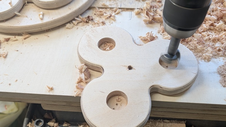 Auf einer Seite die Bohrung größer machen, damit Mutter versenkt werden kann. Zusätzlich 20–30 mm-Bohrungen nur 10–15 mm tief für Leckerli-Fächer. 