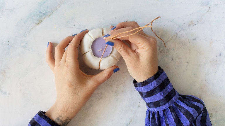 Wichtig ist, dass die Linien immer durch die Mitte verlaufen. Insgesamt werden drei Linien eingedrückt, um die klassische Kürbisform zu erhalten.