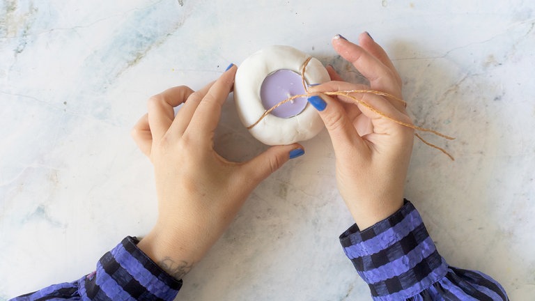 Für die typischen Kürbisrillen eignet sich ein Stück breite Schnur. Diese wird um die Kugel gelegt und leicht in die Masse gedrückt. 