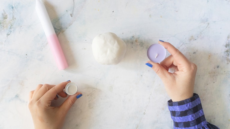 Die Kerzentülle oder das Teelicht mittig in die Kugel drücken.