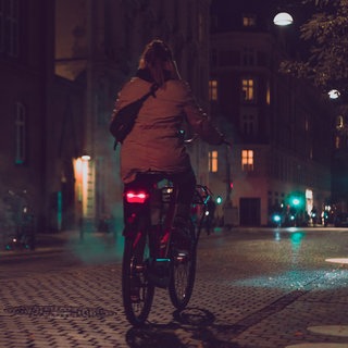 Frau fährt in der Dunkelheit Fahrrad
