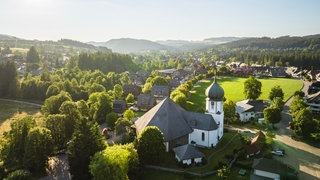 Wandern im Schwarzwald: Blick auf den Ort Hinterzarten und das Bergpanorama im Hintergrund