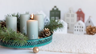 Adventskranz mit kleinen Häusern im Hintergrund