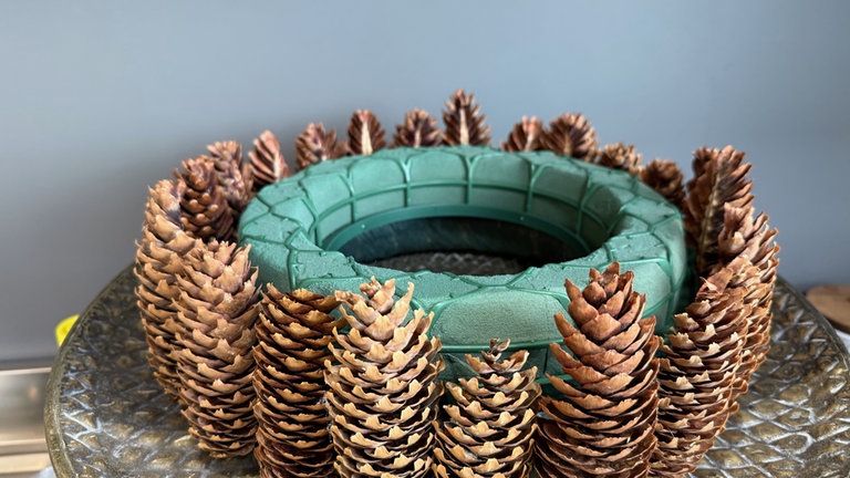 Auf den Strohrömer wird nun in gleicher Größe ein Kranz aus Steckmasse gelegt. 