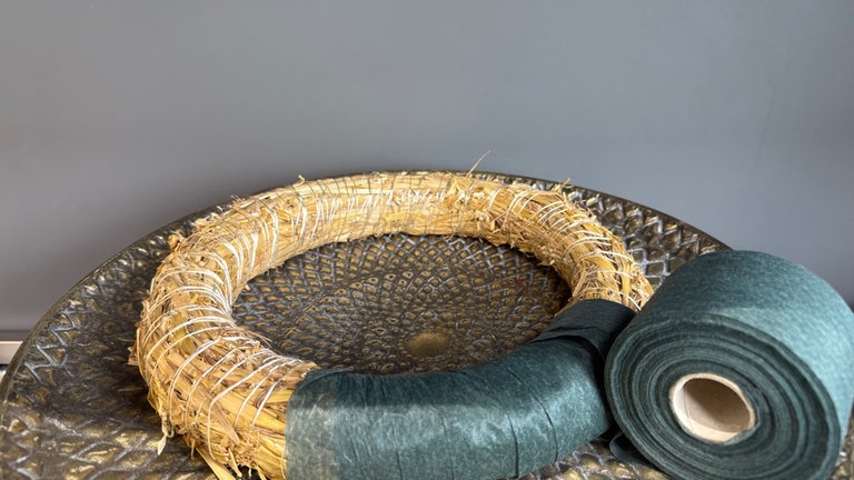 Den Strohrömer mit Filzlunte umwickeln. Wer einen grünen Stoffrest grün hat, kann auch diesen verwenden.