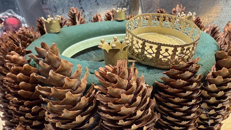 Anschließend werden die Teller für die Kerzen in den Kranz gesteckt.  