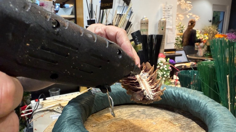 Einen Zapfen mit Heißkleber bestereichen...