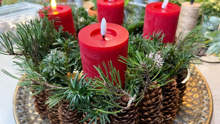  Zum Schluss die Kerzen anbringen. Wer möchte, kann noch Kugeln oder andere Elemente auflegen. 