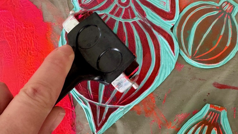 Die Stempelfarbe dünn auf die Glas- oder Acrylplatte geben. Mit der Walze gleichmäßig ausrollen, bis die Farbe leicht klebrig ist (ein leises „Schmatzen“ ist ideal). 