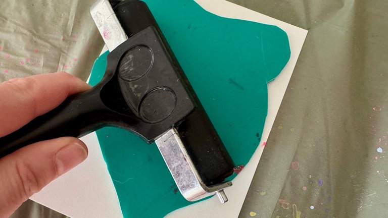 Die Linoleumplatte vorsichtig auf die Karte legen, fest andrücken – am besten mit beiden Händen oder einem Löffelrücken für gleichmäßigen Druck.