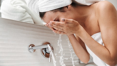 Frau wäscht sich das Gesicht