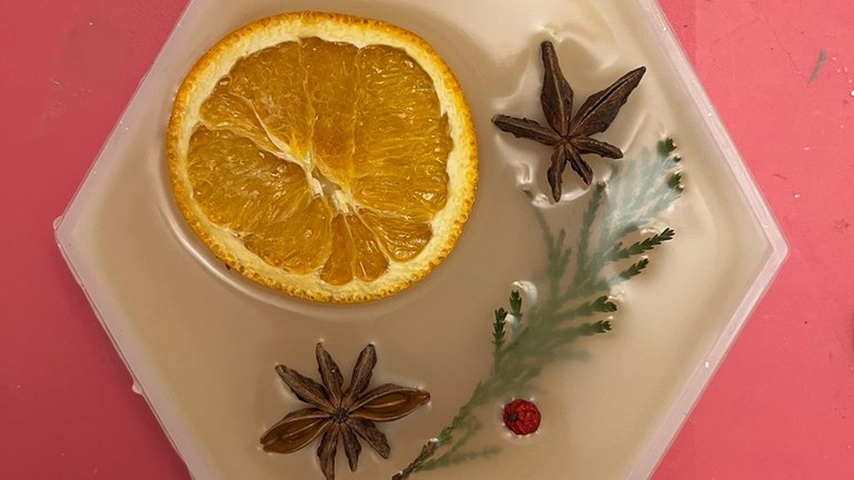Die Anhänger in der Silikonform mit verschiedenen Gewürzen und Trockenblumen oder Glitzer verzieren.