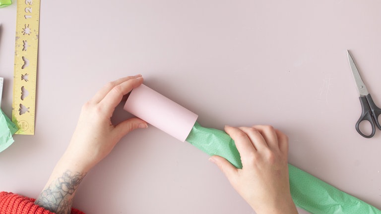 Das eingepackte Geschenk vorsichtig in die Rolle schieben. 