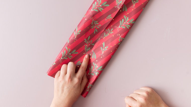 Rechte und linke Seite zur Mitte führen, sodass sie sich 1 cm überlappen, dann mit Klebeband festkleben.