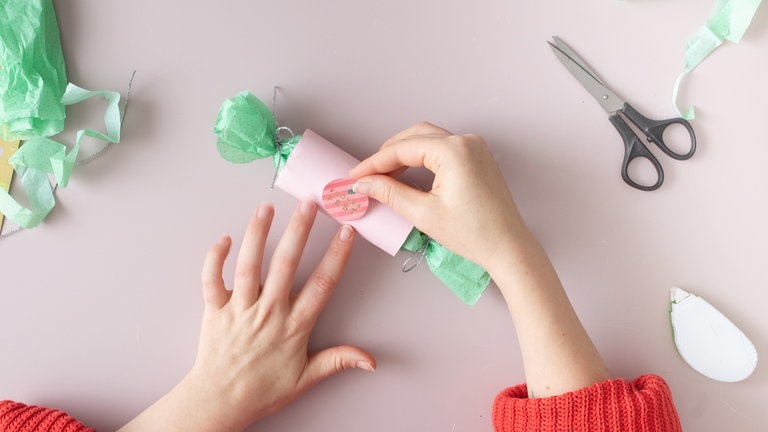 Auf der Tonpapierfläche dekorieren mit Stickern, Stempeln, einem kleinen Namensanhänger oder einer persönlichen Botschaft. 