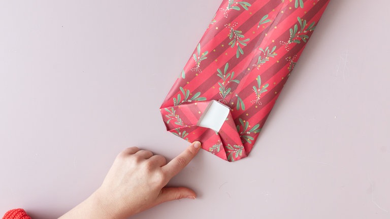 Die beiden entstandenen Klappen zur Mitte falten, sodass sie sich leicht überlappen, und festkleben.