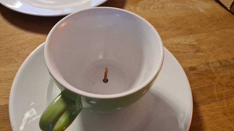 Zuerst die Untertasse auf die Schraube setzen, dann die Tasse darauf stellen und beides von unten am Stamm fest schrauben.