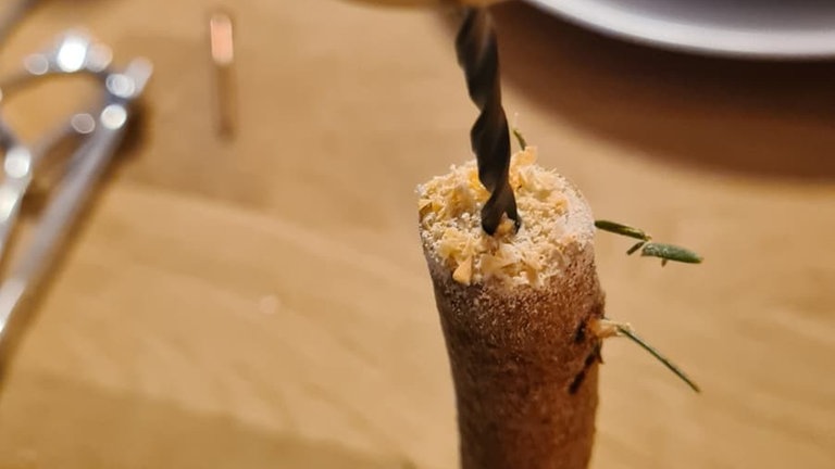 In den Holzstamm oben und unten ein Loch vorbohren, um später die Schrauben leichter eindrehen zu können.