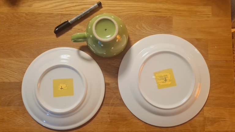 Auf jedem Geschirrteil (großen Teller, Unterteller und Tasse) die Mitte anzeichnen. 