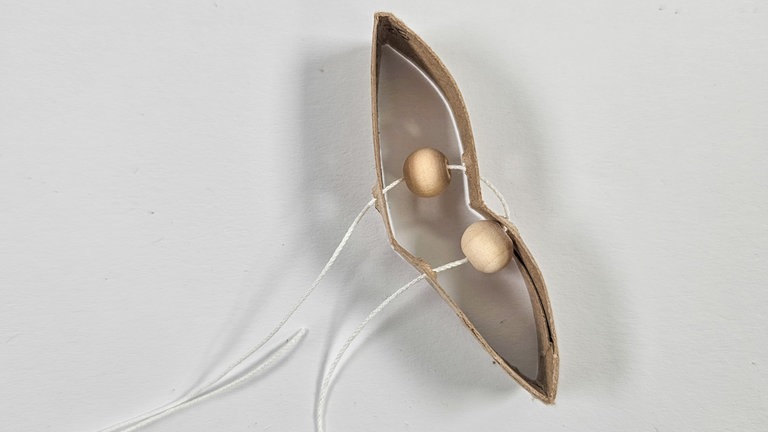 Ein Stück Schnur abschneiden, die Schnur auf eine Nadel ziehen und die Blütenblätter und Perlen aufzuziehen. Dazu die Schnur so durch die vier Löcher ziehen, dass ein Kreis entsteht und mittig zwei Perlen aufgefädelt sind. 