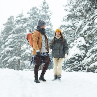 Paar geht im Winter im Wald spazieren