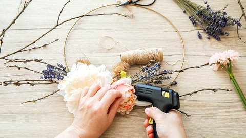 Frau basteln einen Türkranz als Frühlings-Deko