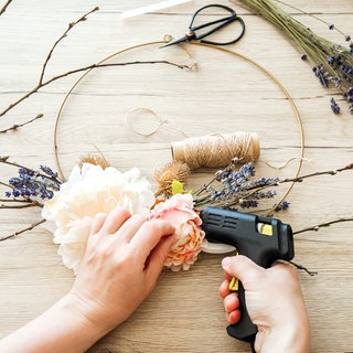 Frau basteln einen Türkranz als Frühlings-Deko