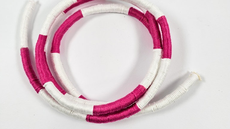 Sobald die gewünschte Anzahl an Runden erreicht ist, das überstehende Seil an beiden Seiten abschneiden.