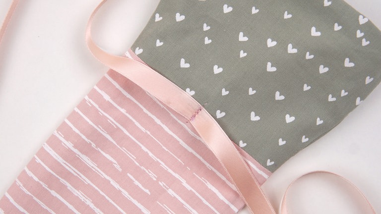 und mit der Nähmaschine oder von Hand mittig auf dem Beutelchen festnähen.