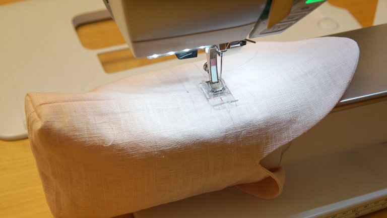 Die zwei Tunnelzugnähte durchgehend steppen. Am einfachsten geht das, wenn Sie das Beutelchen um den Freiarm der Nähmaschine legen. 