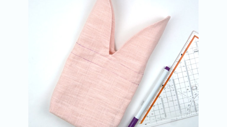 Die Teile ineinanderziehen und die Kanten rundum aufeinanderbügeln. Den Tunnelzug mit einem Trickmarker rundum anzeichnen. 