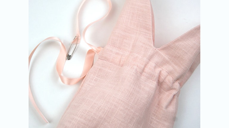 Das Seidenband mit Hilfe einer Sicherheitsnadel durch den Tunnelzug ziehen. 