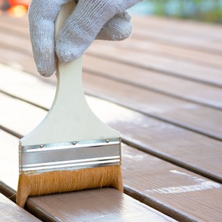 Holz wird mit Pinsel gestrichen