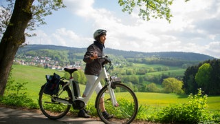 Frau ist mit dem Rad unterwegs