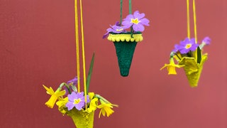 Die Blumen vorsichtig in das Steckmoos stecken und zu einem kleinen Arrangement zusammenstellen. 