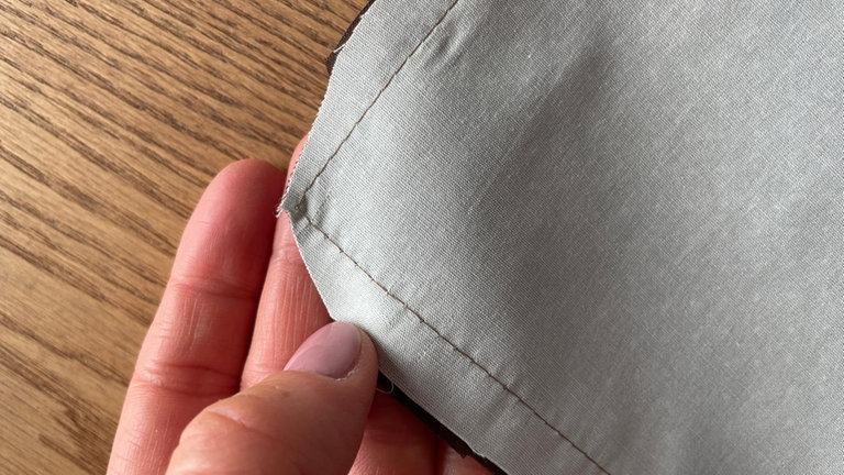 In den Ecken die Nahtzugabe vorsichtig schräg abschneiden, damit die Ecken nach dem Wenden sauber ausformen. 