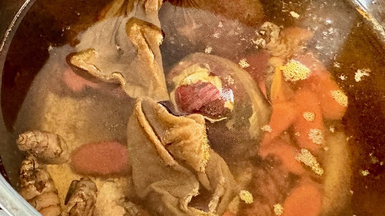 Kurkuma mit Wasser und dem verpackten Ei in einen Topf geben und ca. 10 Minuten kochen. 