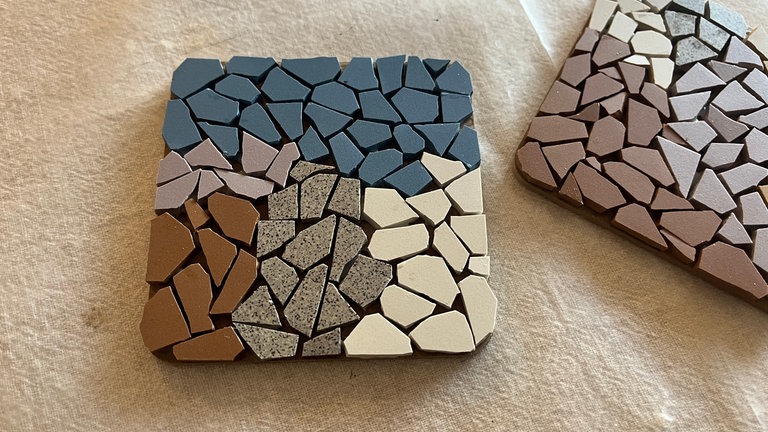 Die Mosaikteile nach Belieben auf die Unterlage setzten.